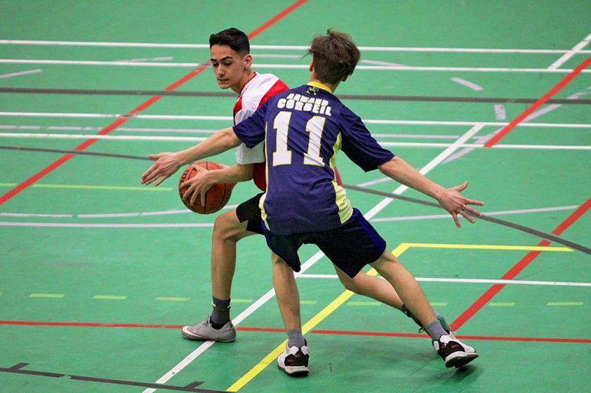 Deux jeunes athlètes en action pendant un match de basketball.