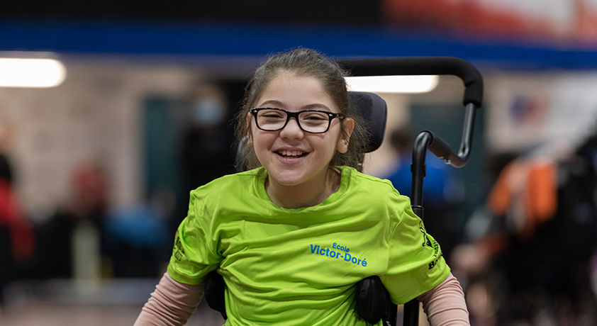 Une fille souriante en fauteuil roulant.