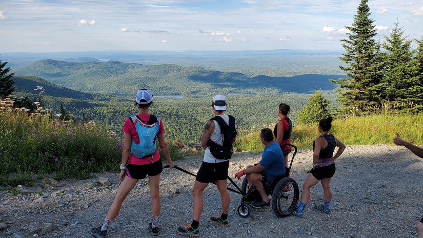 Des randonneurs incluant une personne en fauteuil roulant au sommet du Mont Orford.