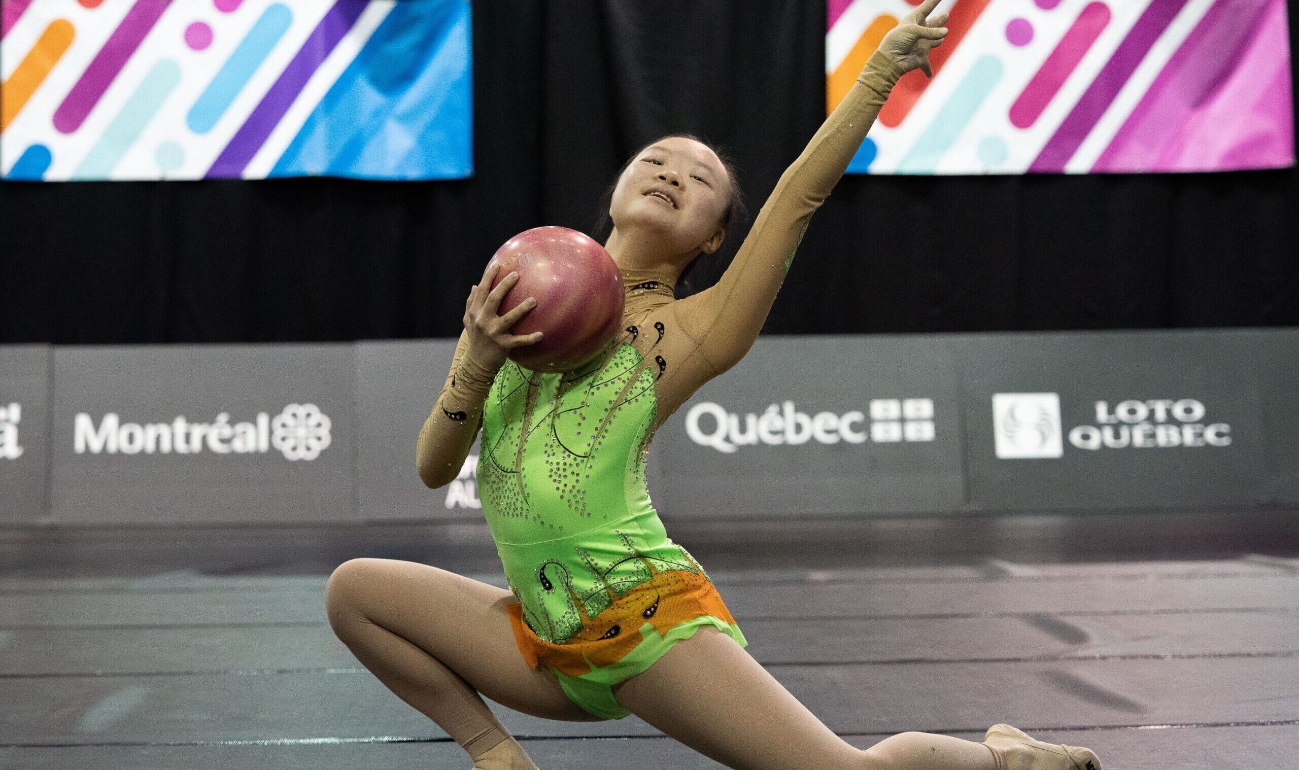 Une athlète agite un ruban pendant une épreuve de gymnastique rythmique.