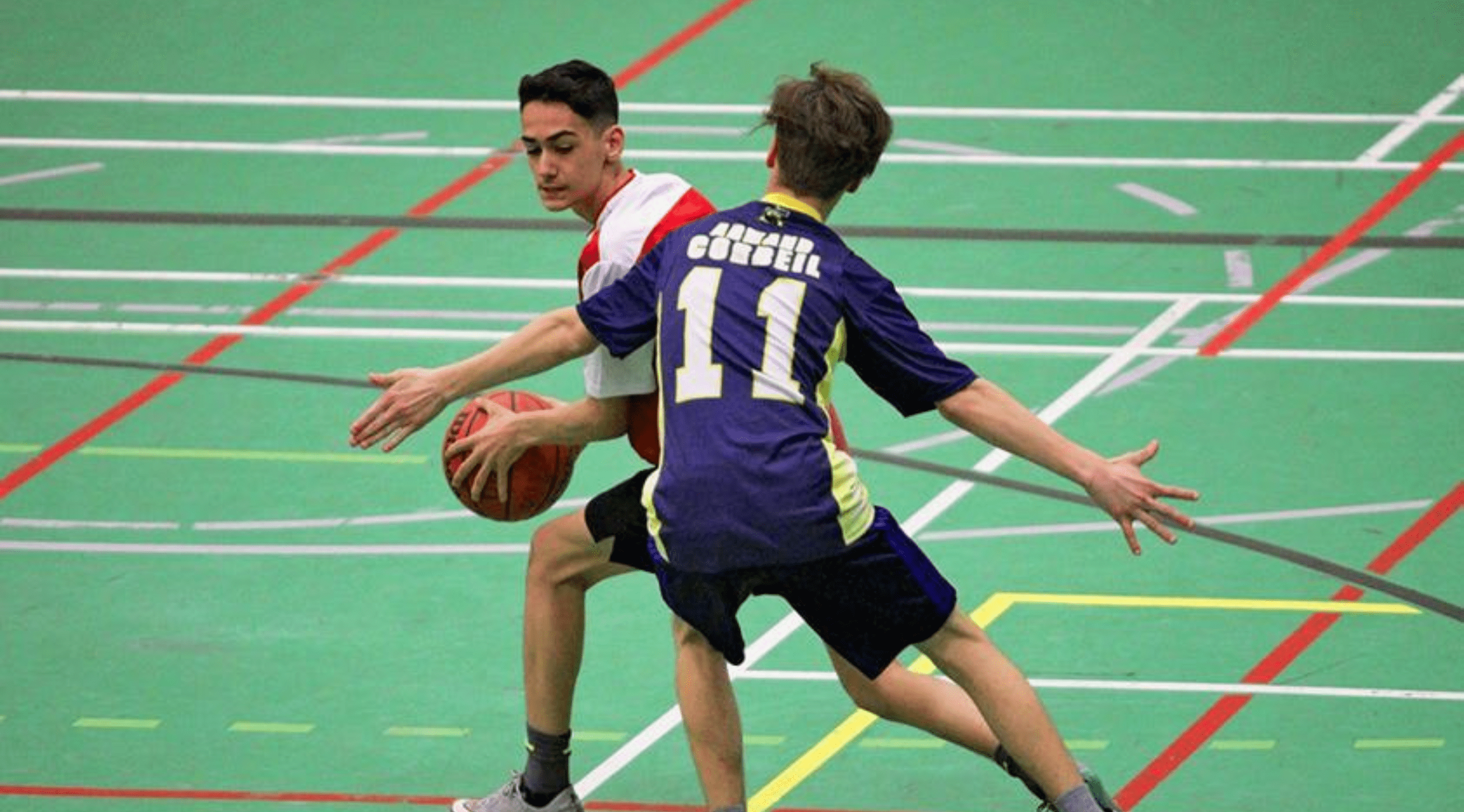 Deux jeunes athlètes en action pendant un match de basketball.