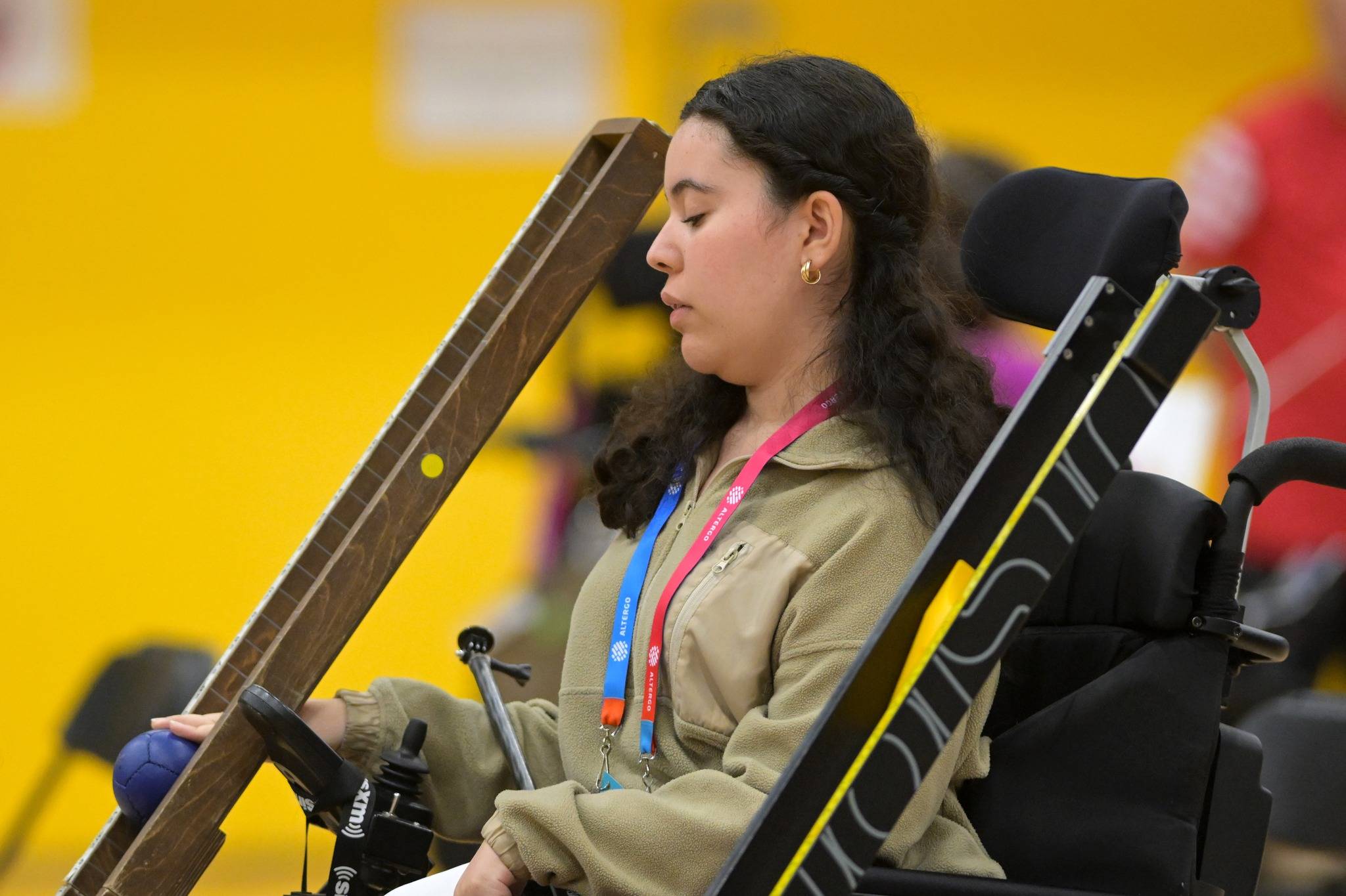 Une jeune femme s'apprête à envoyer sa balle de boccia à partir de sa rampe.