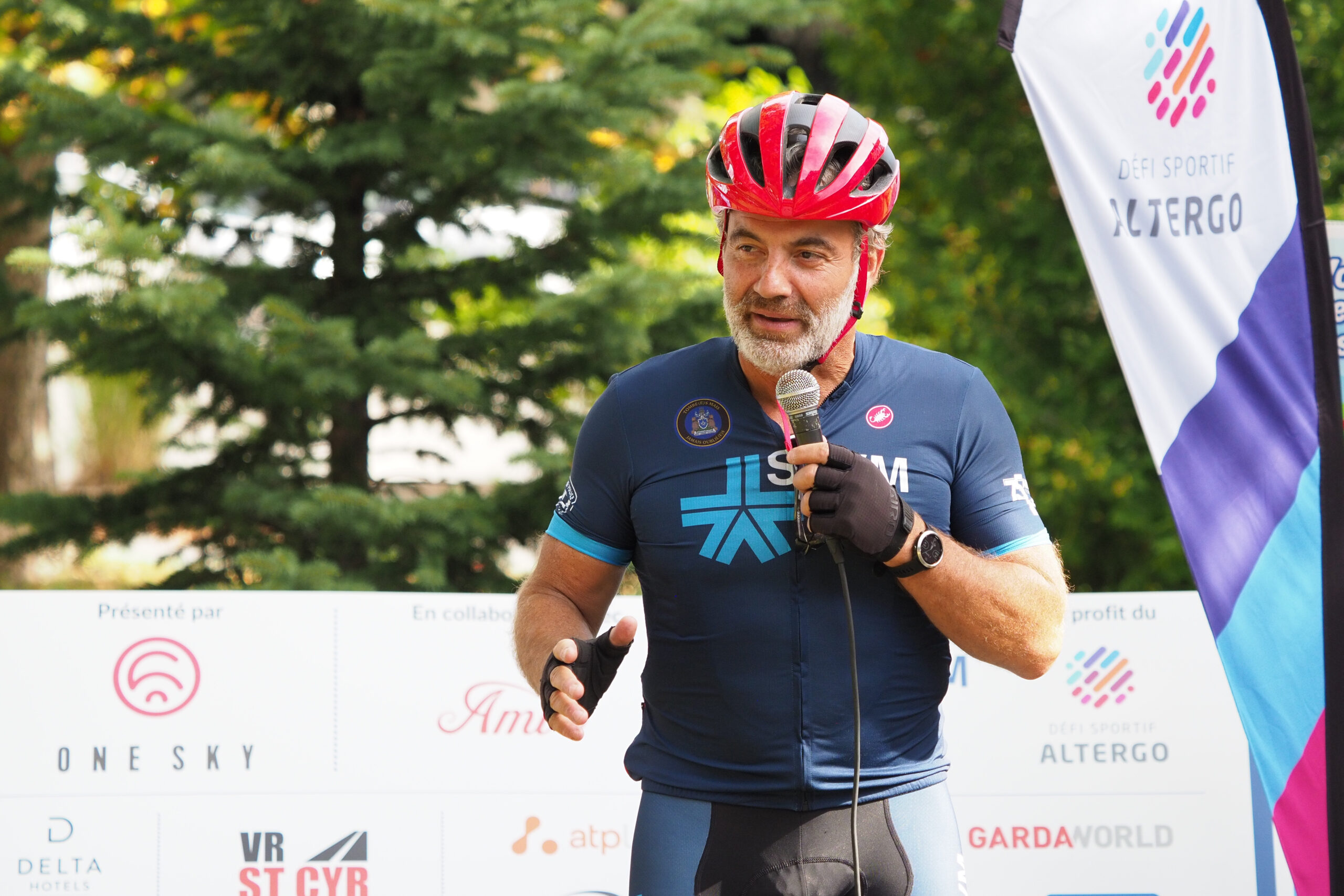Fady Dagher, un homme en maillot de vélo du SPVM, parle au micro.
