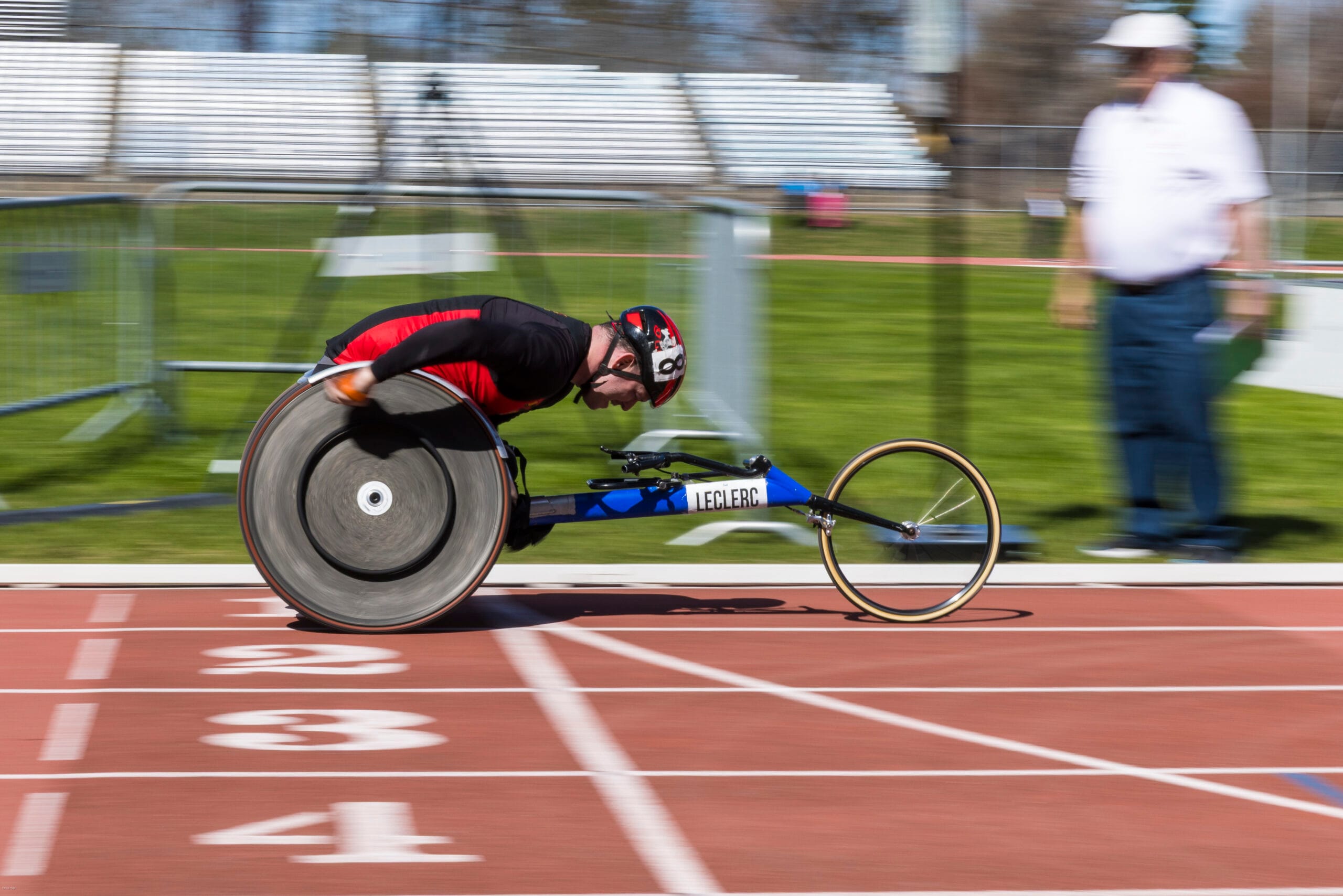 Un joueur en fauteuil roulant tient un ballon de basketball.