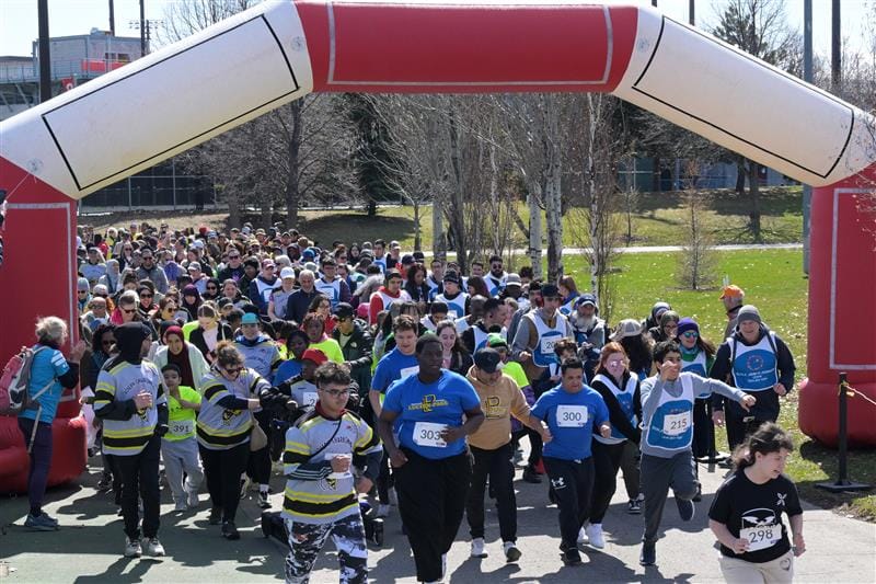 Une groupe de jeunes coureurs à la ligne d'arrivée du mini-marathon