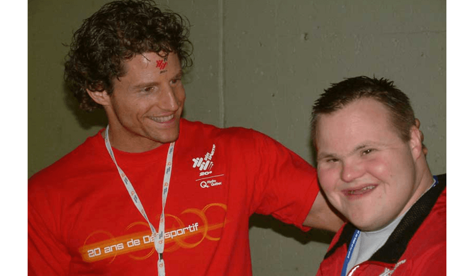 Une jeune Jean-Marie Lapointe sourit avec un athlète du 20e Défi sportif AlterGo.